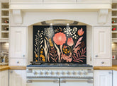 May include: A white kitchen with a black floral patterned backsplash behind a white range with six burner stovetop and two ovens. The backsplash features pink, orange, and yellow flowers and leaves on a black background.