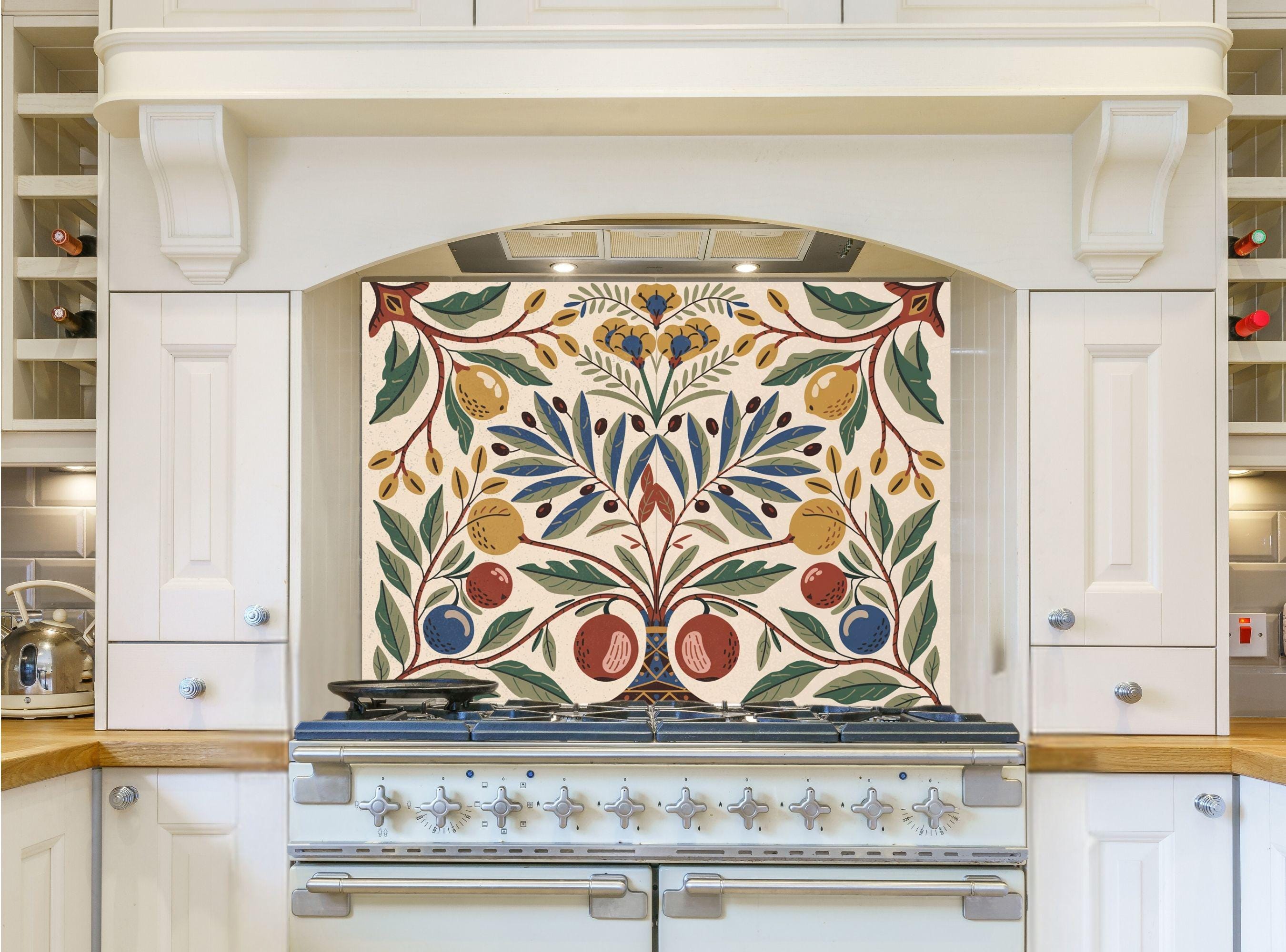 May include: A white kitchen with a range hood and a range with a decorative tile backsplash featuring a stylized floral design with yellow, red, blue, and green leaves and fruit. The backsplash is cream colored with a white border.