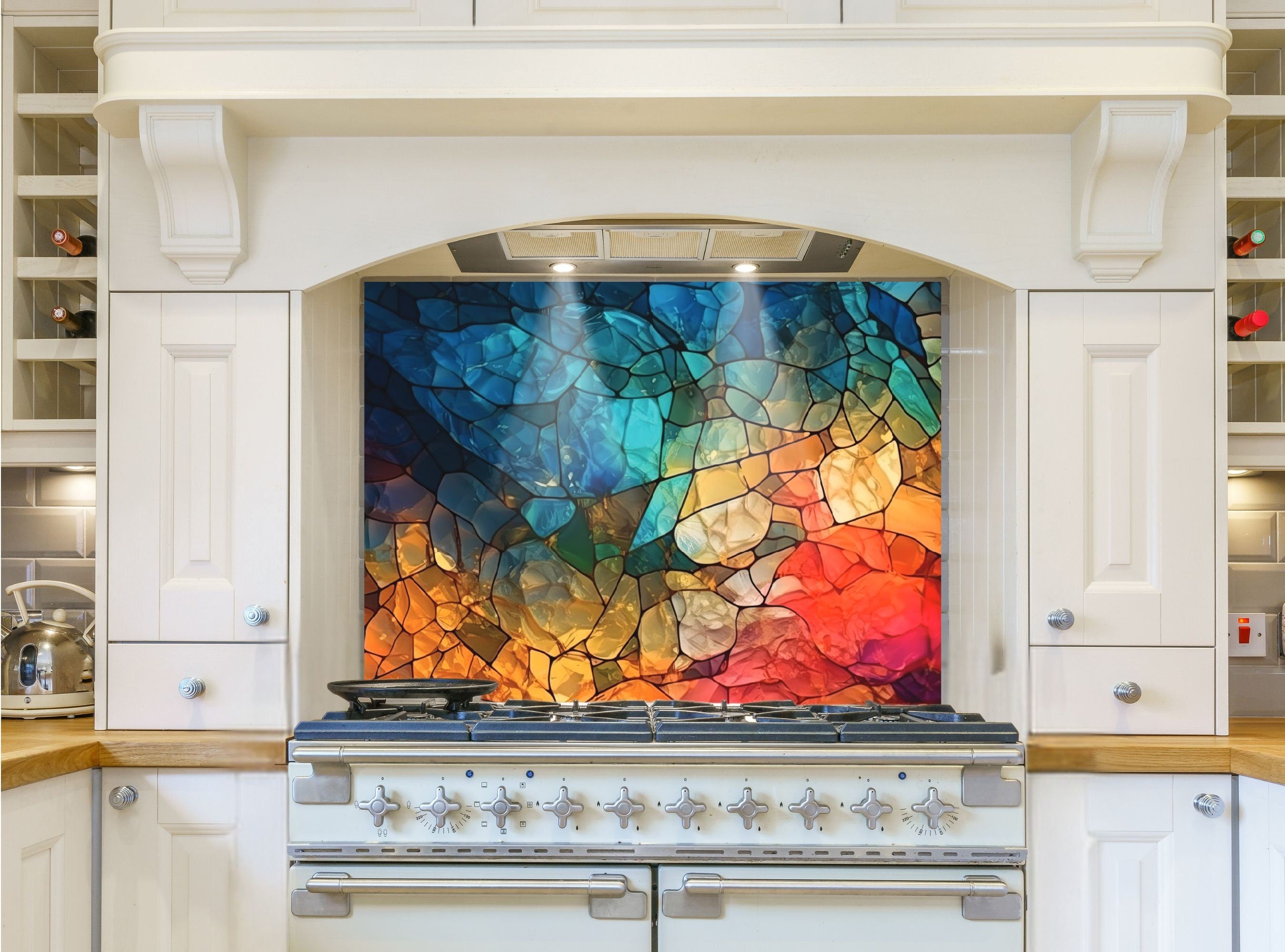 May include: A white kitchen range with a colorful stained glass backsplash. The backsplash has a mosaic design of blue, green, yellow, orange, and red. The range has a black cooktop with eight silver knobs and a silver oven door.