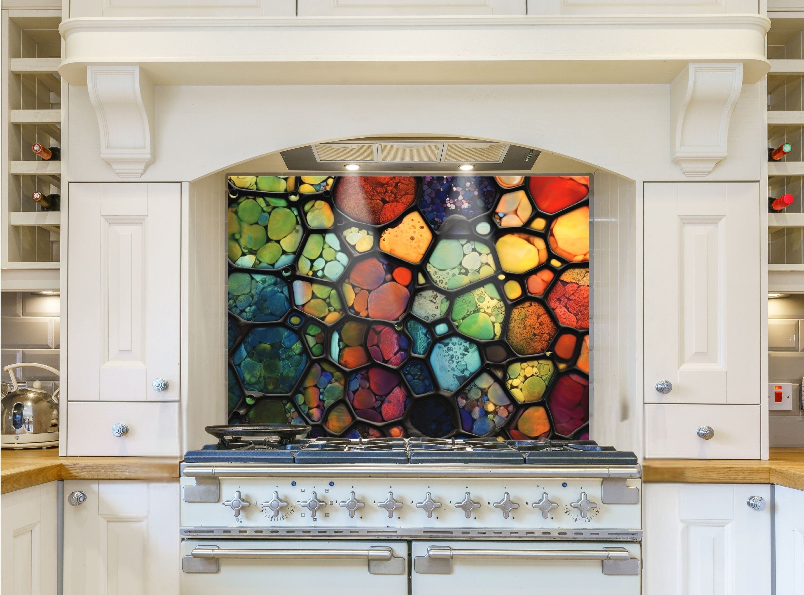 May include: A colorful stained glass style kitchen backsplash with a variety of colors including red, orange, yellow, green, blue, and purple. The backsplash is installed above a white stove with silver knobs.